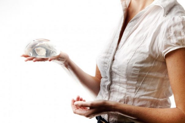Woman holds breast implant