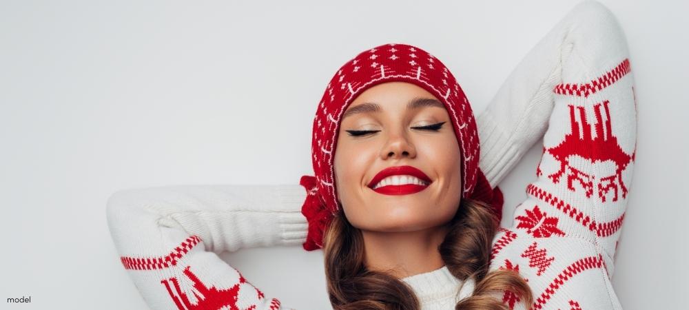 Beautiful woman wearing Christmas sweater, hat and mittens