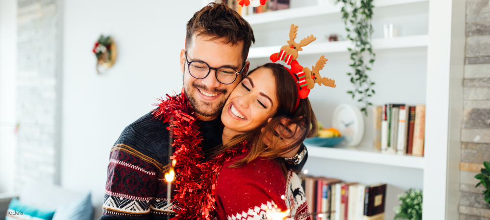 Happy man and woman at Christmas hugging and smiling