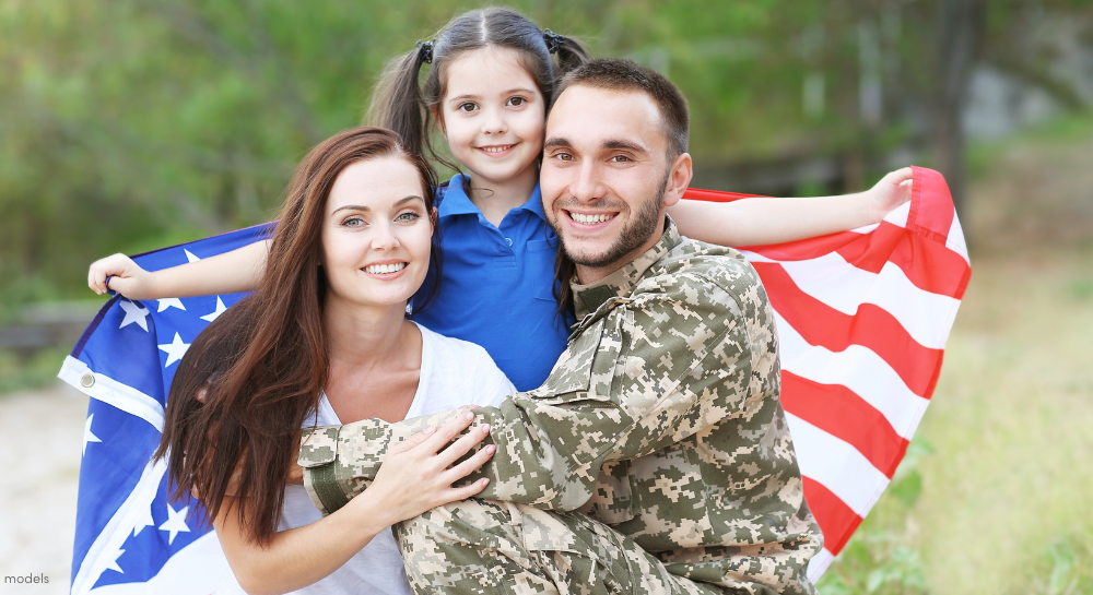 Military family holding USA flag