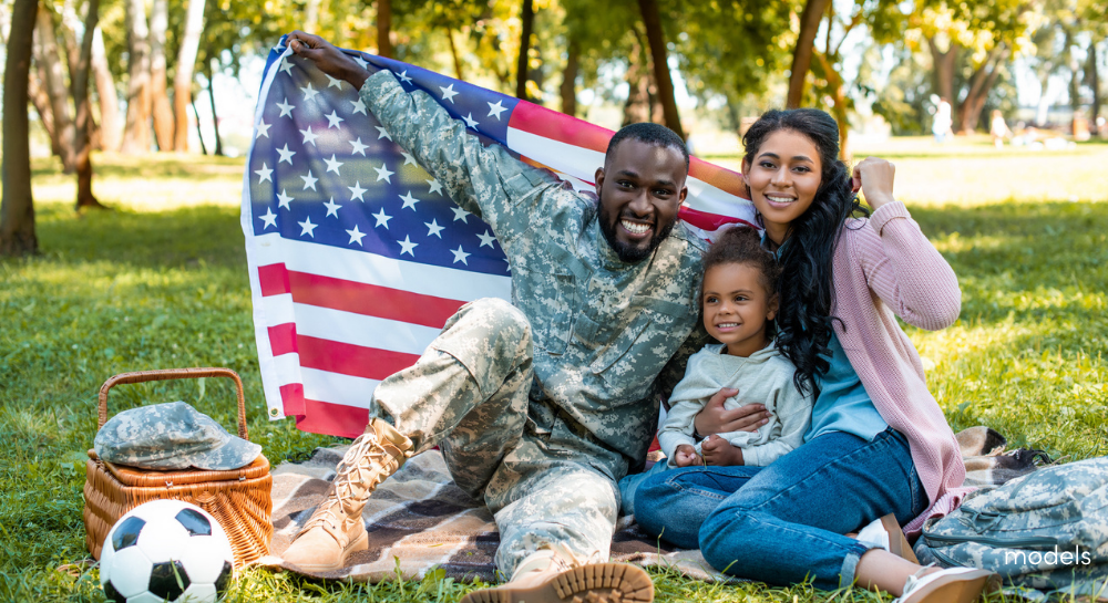 Military family holding USA flag