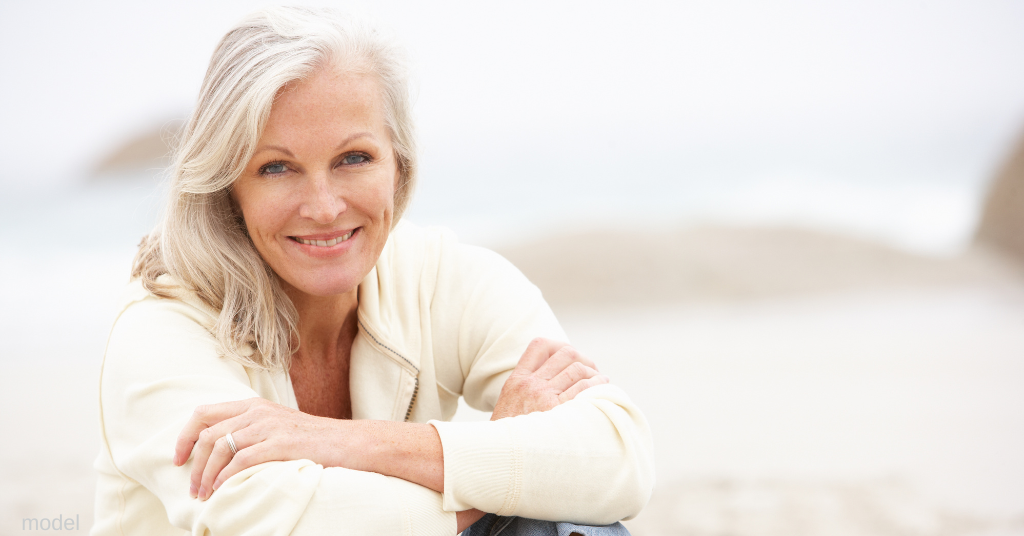 Image of woman on the beach smiling after facelift recover (model)