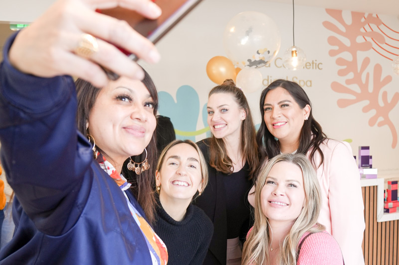 Women taking a selfie in front of the reception desk of La Jolla Cosmetic Medical Spa in Carlsbad, CA