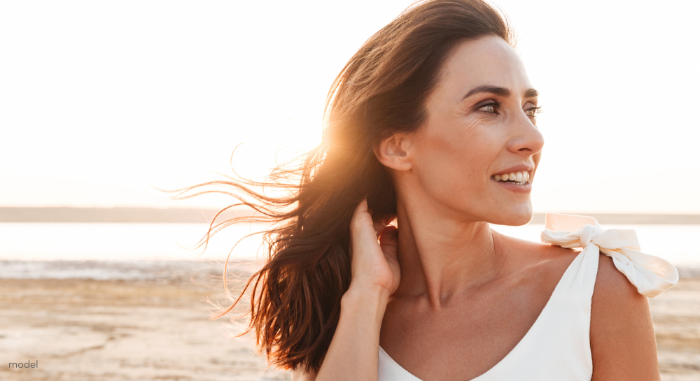 Beautiful woman at the beach looking off to the side