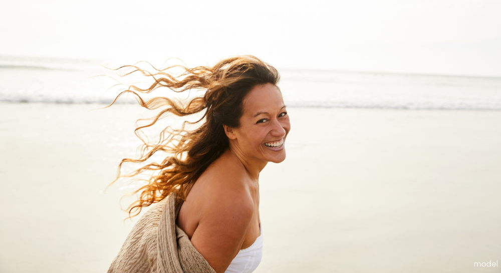 Woman at the beach smiling and looking at camera