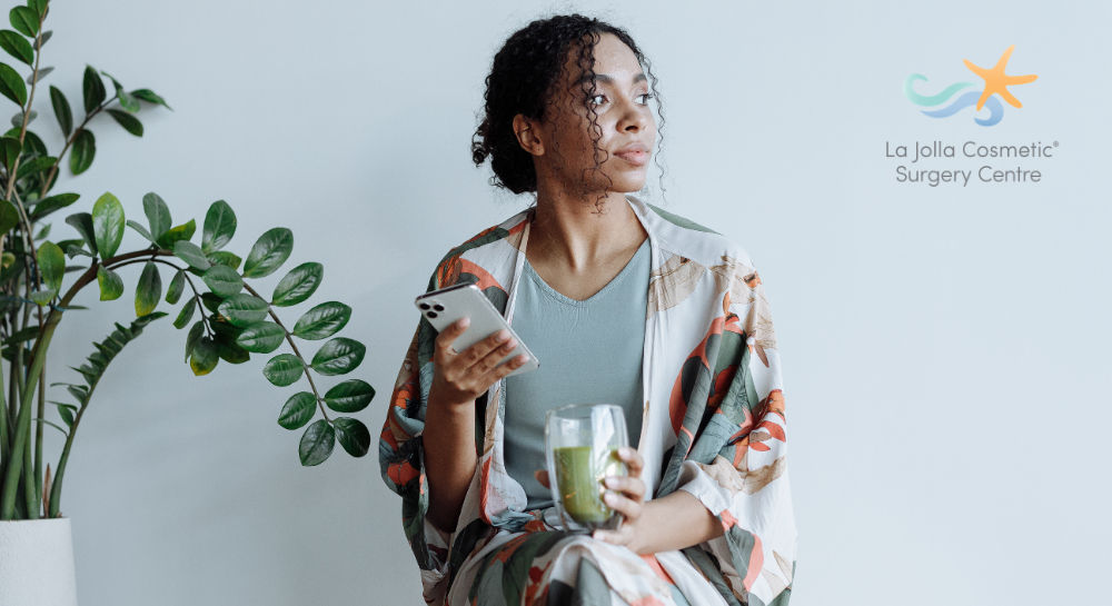 Woman holding a matcha drink and thinking and looking away from the camera