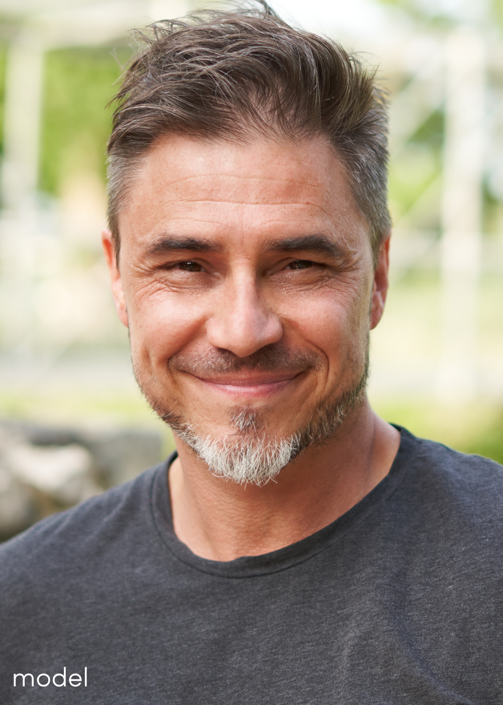 Guy in a grey t-shirt looking at the camera and smiling