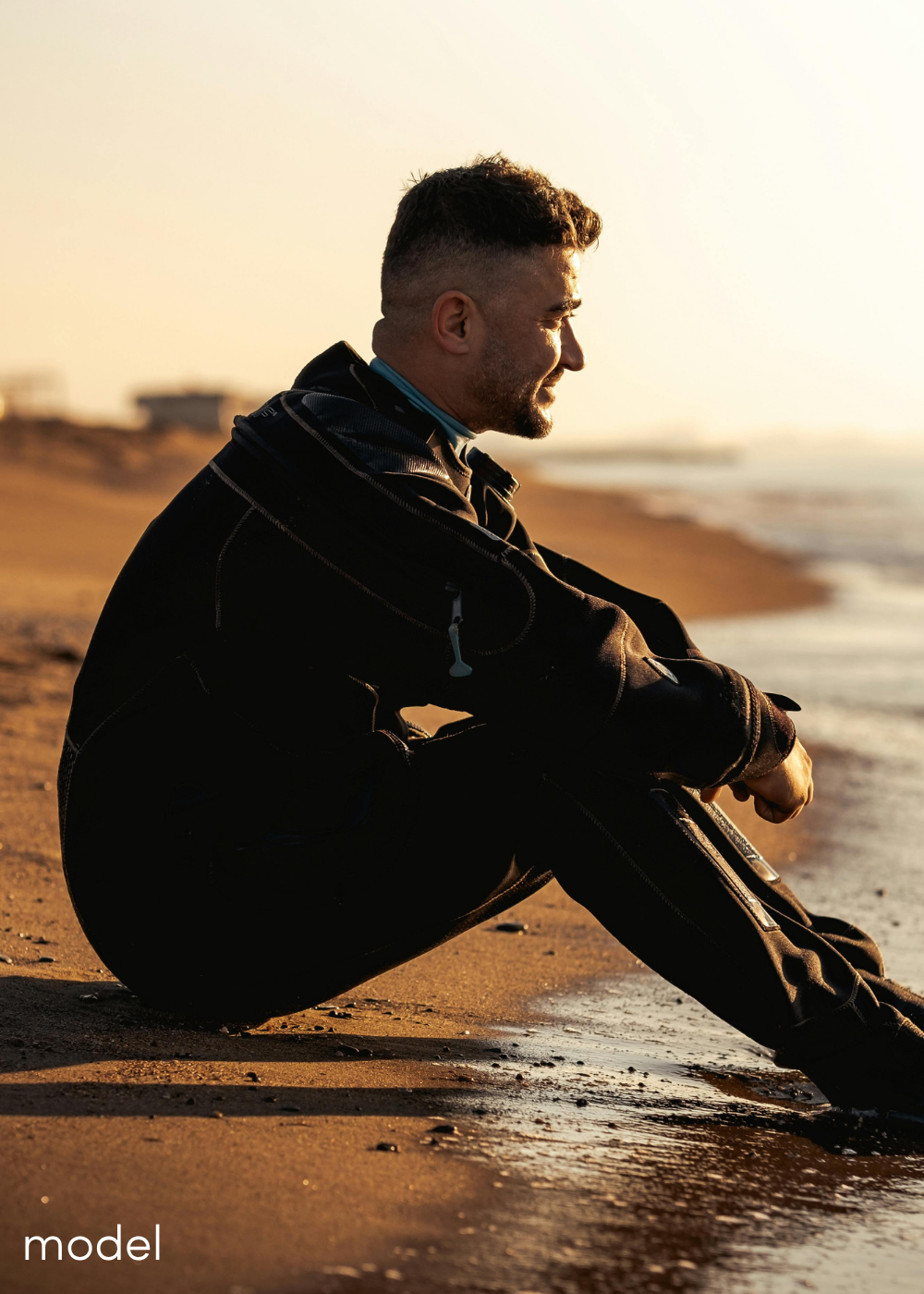 Guy sitting on the beach at sunset