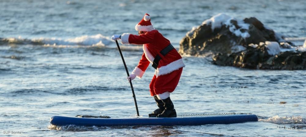 Santa Stand Up Paddling in the Ocean