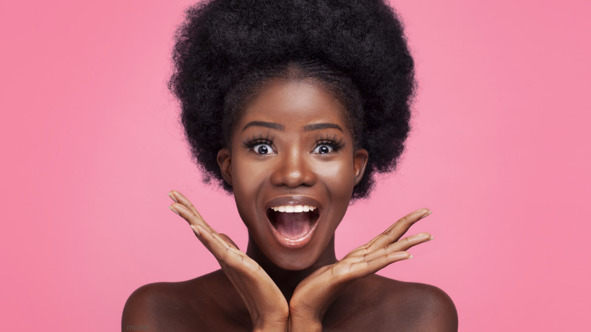 African American woman with excited face against pink background