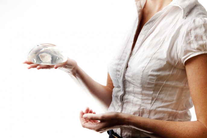 woman-holding-breast-implant woman-holding-breast-implant